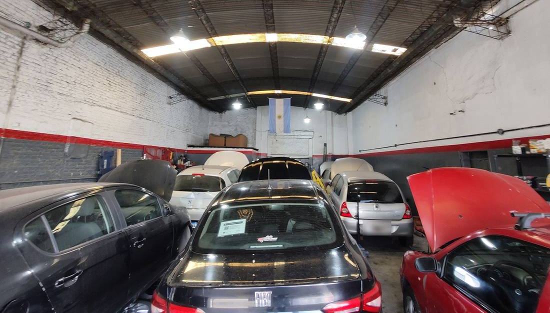 Interior del taller GF Racing con autos en reparación